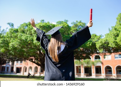 back view of girl gratuate happily at campus with diploma holding in her hand