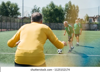 Back View Of Goalkeeper And Elderly Men On Football Field