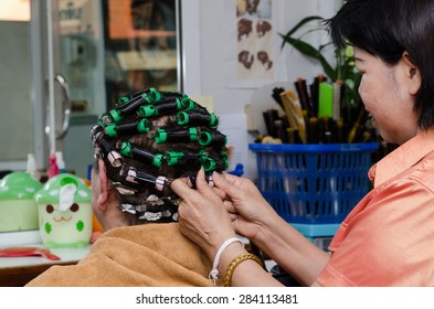 Back View Of The Good Looking Asian Old Woman Making Hair Curl In The Beauty Salon