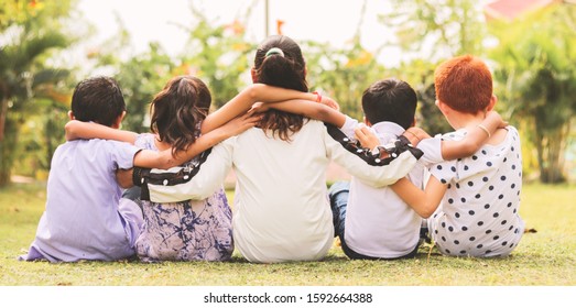 Back View, Group Of Kindergarten Multi Ethnic Kids Friends Arm Around Sitting Together At Park Outdoor - Concept Showing Of Childhood Friendship, Togetherness With Diversities.