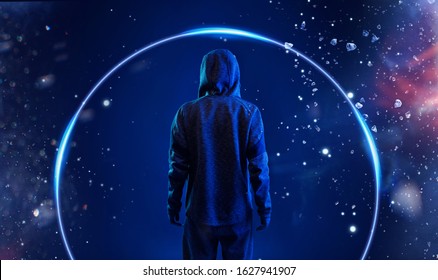Back view of hacker in hoodie. Dangerous hooded hacker. Internet, cyber crime, cyber attack, system breaking and malware concept. Anonymous. Dark background. Blue neon light.