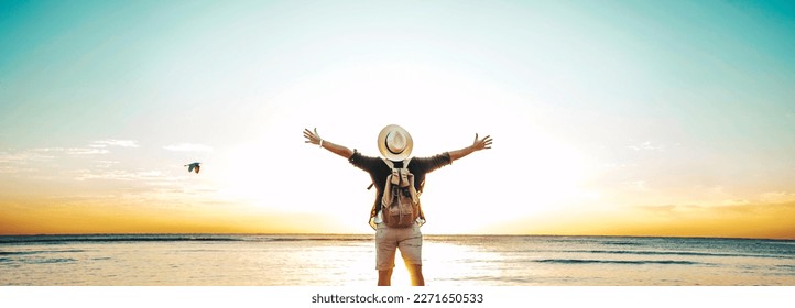 Back view of happy excited man raising arms up to blue sky - Hipster winner traveler enjoying summer sunset at the beach - Travel, mental health, success, business, tourism and life style concept - Shutterstock ID 2271650533
