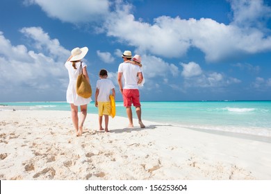 Back View Of A Happy Family On Tropical Beach