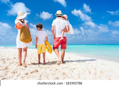 Back View Of A Happy Family On Tropical Beach