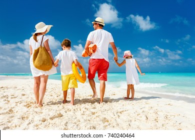 Back View Of A Happy Family At Tropical Beach On Summer Vacation