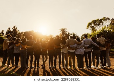 Back view of happy multigenerational people having fun in a public park during sunset time - Community and support concept  - Shutterstock ID 2289028551
