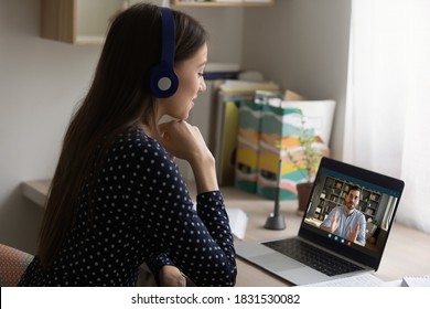 Back view happy young businesswoman involved in online videocall with partner, suing computer application, quarantine lifestyle concept. Smiling employee consulting with company leader distantly.