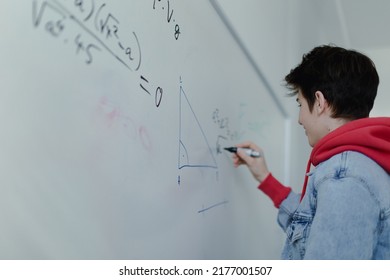 Back View Of High School Student Solving Math Problem On Whiteboard In Classroom.