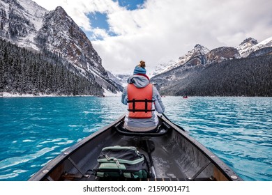 A Back View Of A Hiker In A Lifejacket In A Sailboat On Lake Louise In Canada