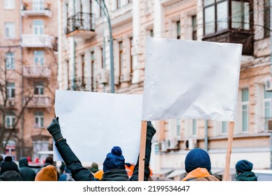 Back view of a huge crowd with white cardboard banners in their hands protesting on the street. Revolution. Demonstration. Woman. Sign. City. Street. Crowd. Freedom. Activist. Democracy. Strike