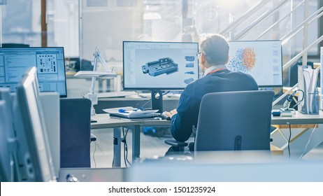 Back View of Industrial Engineer Working on Desktop Computer in Bright Office. Screens Show IDE / CAD Software, Implementation of Machine Learning, Neural Networking and Cloud Computing