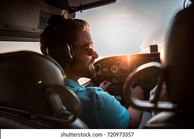 Back view from the inside of the plane, couple in aviation headsets is ready to fly