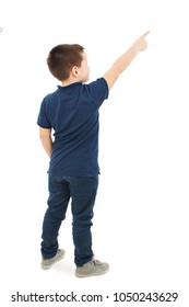 Back view of little boy points at wall. Rear view. Isolated on white background 