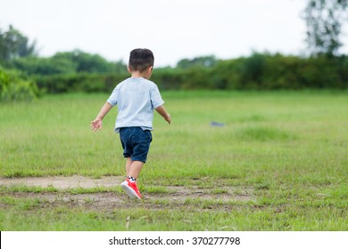 Back View Of Little Boy Running At Park