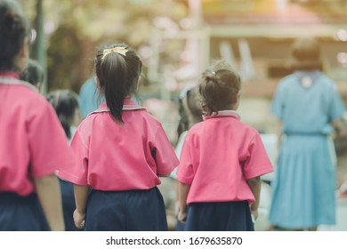 Back View Of Little Girls Use Paper Rolls Instead Of Long Cheerleader Baton Sticks For School Parade Marching Practice.