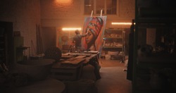 Back View Of Male Artist Painting Portrait Of Black Woman On Easel Against Lamp During Work In Spacious Workshop