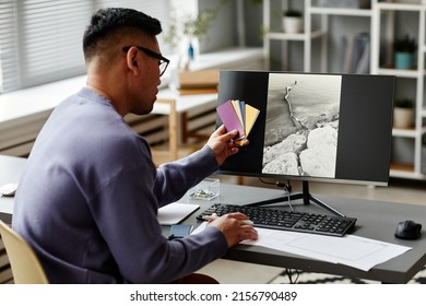 Back View At Male Editor Comparing Color Swatches To Pictures On Computer Screen While Working In Office, Copy Space