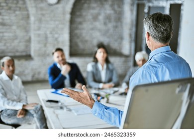 Back view of a male manager talking on business seminar in board room.  - Powered by Shutterstock