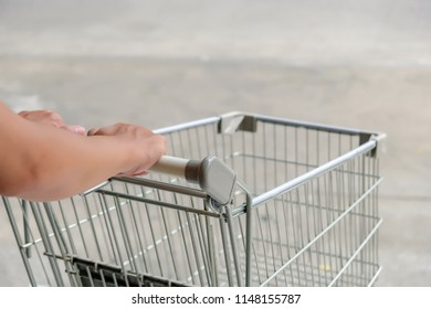 Back View Of Male's Hands Trolling Supermarket Shopping Cart