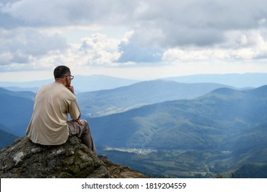 Back view of a man admiring amazing view on top of the mountain - Powered by Shutterstock