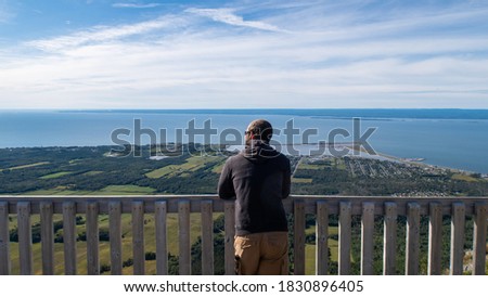Back view of a man admiring the panoramic view from the mont Saint-Joseph, in Carleton-sur-mer, Canada