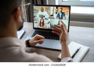 Back View Of Man Businessman Working On Laptop At Home Office. Over Shoulder Shot Of Guy Having Virtual Training On Video Call Meeting, Running Online Webinar Or Seminar Using Computer