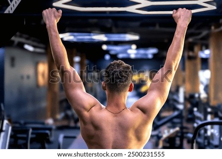 Back view of a man doing push-ups in the gym. Sports lifestyle.