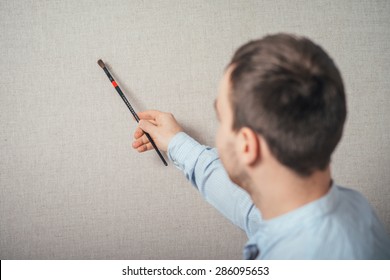 back view of a man drawing with  on canvas at his painting studio 