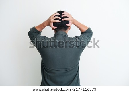Back view of a man grabbing his head showing stress gesture