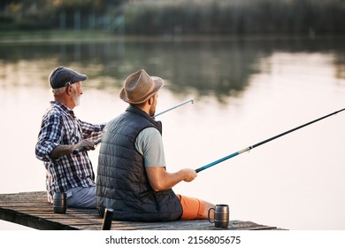 Back view of man and his senior father enjoying in freshwater fishing while relaxing on a pier. Copy space. - Shutterstock ID 2156805675
