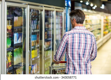 Back View Of Man Holding Cart In Supermarket