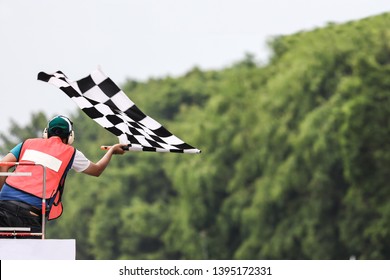 Back view of man holding checkered race flag