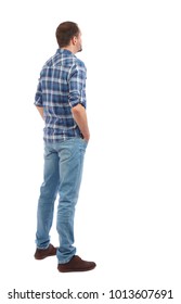 Back View Of Man In Jeans. Standing Young Guy. Rear View People Collection.  Backside View Of Person.  Isolated Over White Background. A Man In A Blue Shirt Stands By Putting His Hands In His Pockets