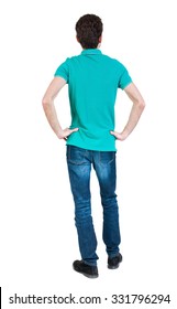 Back View Of Man In Jeans. Standing Young Guy. Rear View People Collection.  Backside View Of Person.  Isolated Over White Background. A Guy In A T-shirt Is Stylish Aquamarine Hands On Hips.