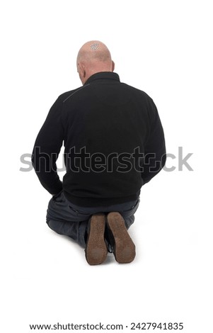 back view of a man kneeling on the floor in white background