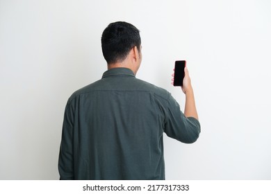 Back view of a man looking to the mobile phone that he hold - Shutterstock ID 2177317333