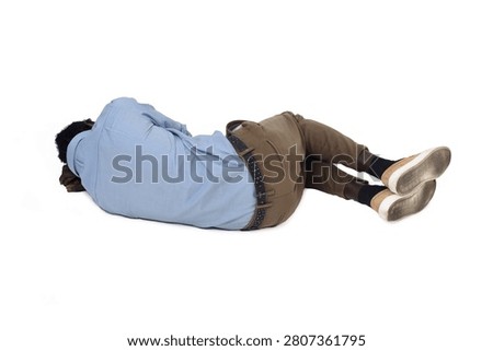 back view of a man lying on the floor in the fetal position