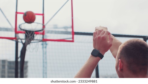 Back view of man player throwing ball in a basketball hoop. Successfully throws ball into the basket ring. Sport lifestyle. - Powered by Shutterstock