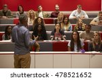 Back view of man presenting to students at a lecture theatre