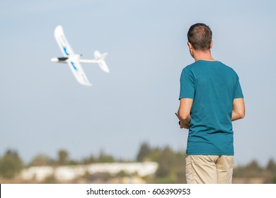 Back View Of Man With Remote Control Plane Flying In Air
