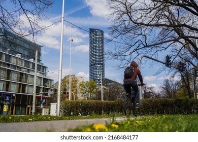 Back View Of Man Riding Bike On Urban Street In Wroclaw