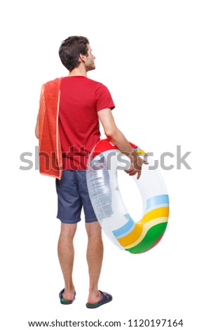 Back view of a man in shorts with an inflatable circle. The guy on the beach. Rear view people collection.  backside view of person. Isolated over white background. young guy looks around at the beac