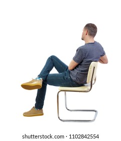 Back View Of A Man Sitting On A Chair. Rear View People Collection.  Backside View Of Person.  Isolated Over White Background. The Student Listens To The Lecture Comfortably Sitting On A Chair