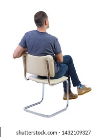 Back View Of A Man Sitting On A Chair. Rear View People Collection. The Guy Sits Cross-legged. Backside View Of Person. Isolated Over White Background.