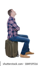 Back View Man Sitting On  Suitcase. Waiting At Station. Backside View Person.  Rear View People Collection. Isolated Over White Background. Guy With Travel Bag On Wheels Looking At Something At Top