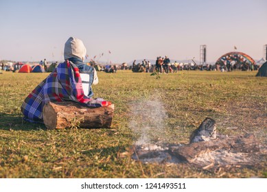 Back View Of Man Sitting Wooden On The Grass, Enjoying An Outdoors Music, Culture, Community Event, Festival,Funny Group Of Young Girls And Boys At Music Festival, Happy Teen At Winter Festival.