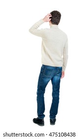 Back View Of Man . Standing Young Guy. Curly Short-haired Guy In A White Jacket Wool Scratching Hand To Head.