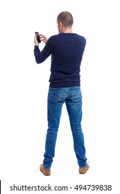 Back View Of Man In Suit  Talking On Mobile Phone.    Rear View People Collection. Isolated Over White Background. Backside View Of Person. Man In Black Warm Sweater Holding A Phone.