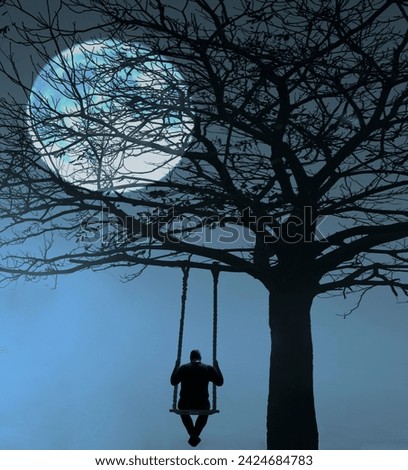 Back view of man swinging on the wooden swing on big leafless tree. Scenic landscape. rear view of middle age unrecognisable man swinging on swing with rope under mountains. full moon behind branches.
