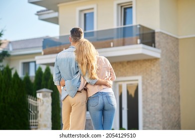 Back view of man and woman looking at house - Powered by Shutterstock